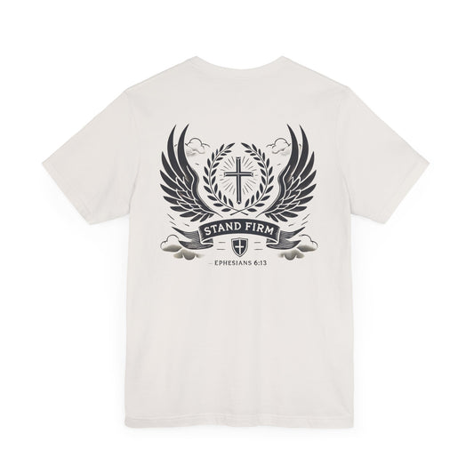 Stand Firm Tee in vintage white, featuring a bold Christian design with a cross, laurel wreath, wings, and clouds in a traditional tattoo-inspired style. Inspired by Ephesians 6:13, it symbolizes faith, strength, and spiritual protection, appealing to those with a love for bold and meaningful artwork